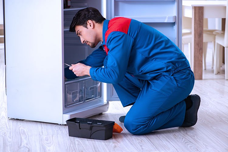 Technician checking refrigerator components